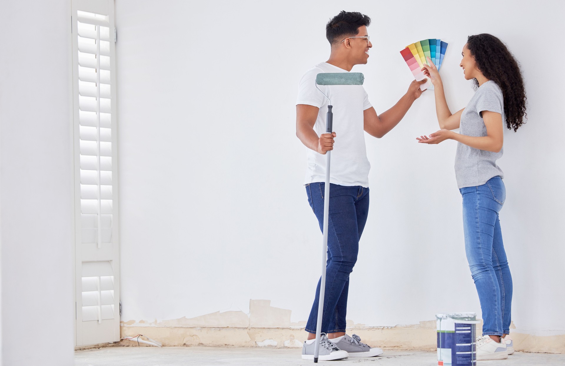 Shot of a young couple looking at color swatches while painting a room